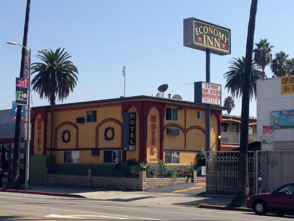 un edificio amarillo con un cartel delante en Economy Inn Hollywood, en Los Ángeles