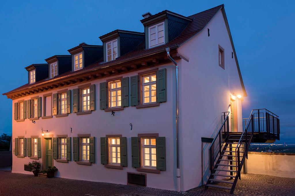 a white building with a staircase in front of the ocean at Burggarten Appartements Neuleiningen in Neuleiningen