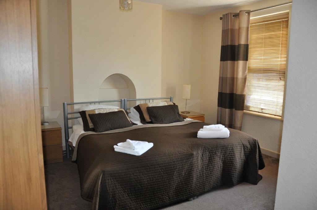 a bedroom with a bed with two towels on it at Holly Tree Guest House in Hereford