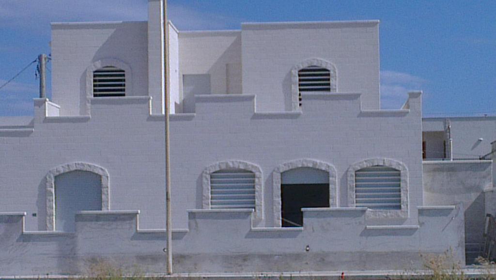 ein weißes Gebäude mit Seitenbögen in der Unterkunft Castle on the Sea in Torre Santa Sabina