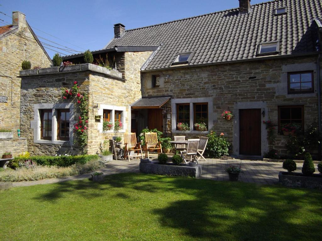 a stone house with a patio and a yard at Un Air de Campagne in Sprimont