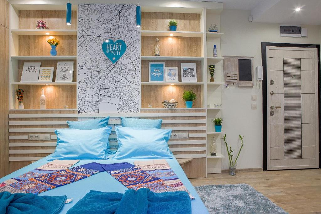 ein Schlafzimmer mit einem Bett mit blauen Kissen in der Unterkunft City center Apartment in Sofia