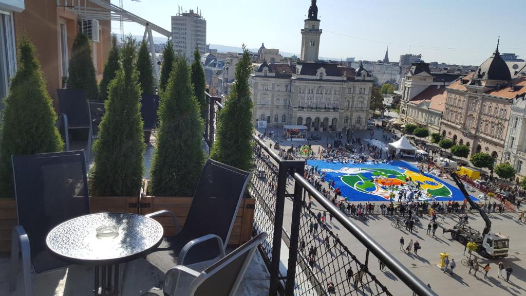 a view of a city from a balcony with a table at NS center apartment in Novi Sad