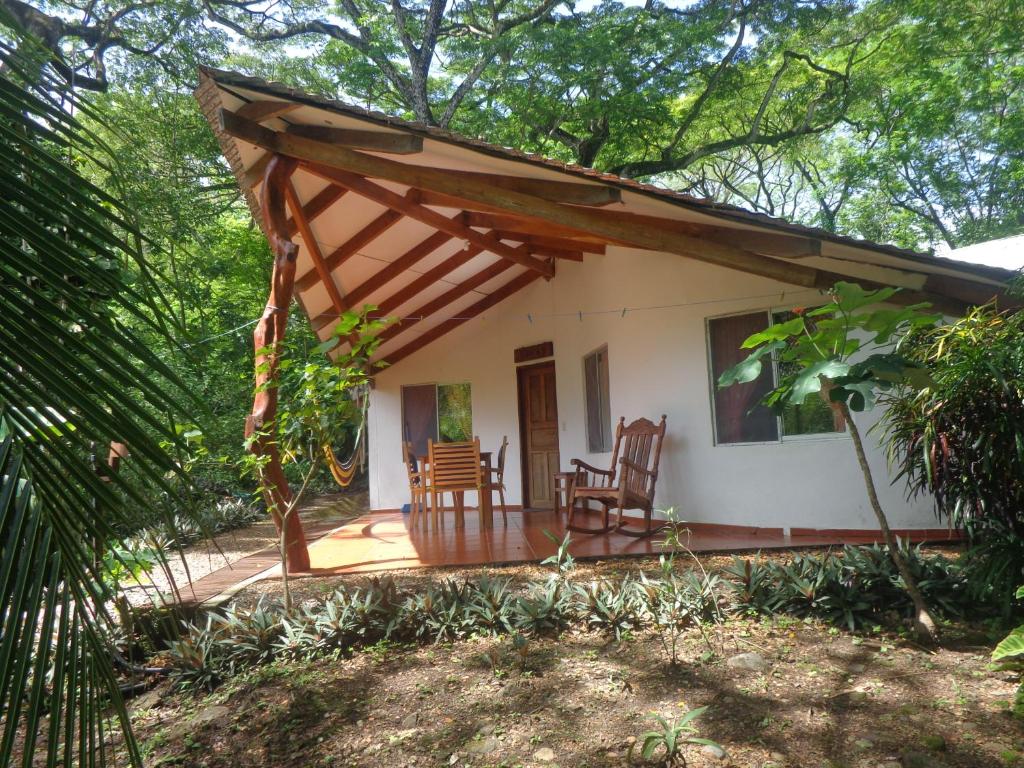 ein Cottage im Wald mit 2 Stühlen und einer Veranda in der Unterkunft Cabañas Cañas Castilla in La Cruz