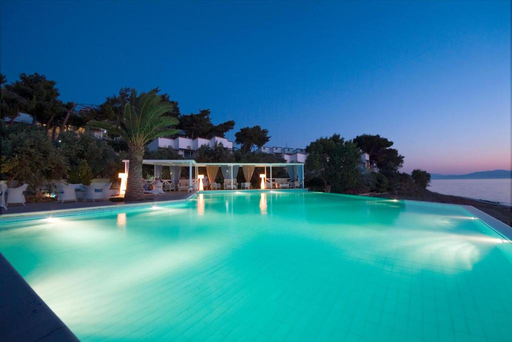 a large swimming pool at night at Venus Beach Hotel in Nea Stira