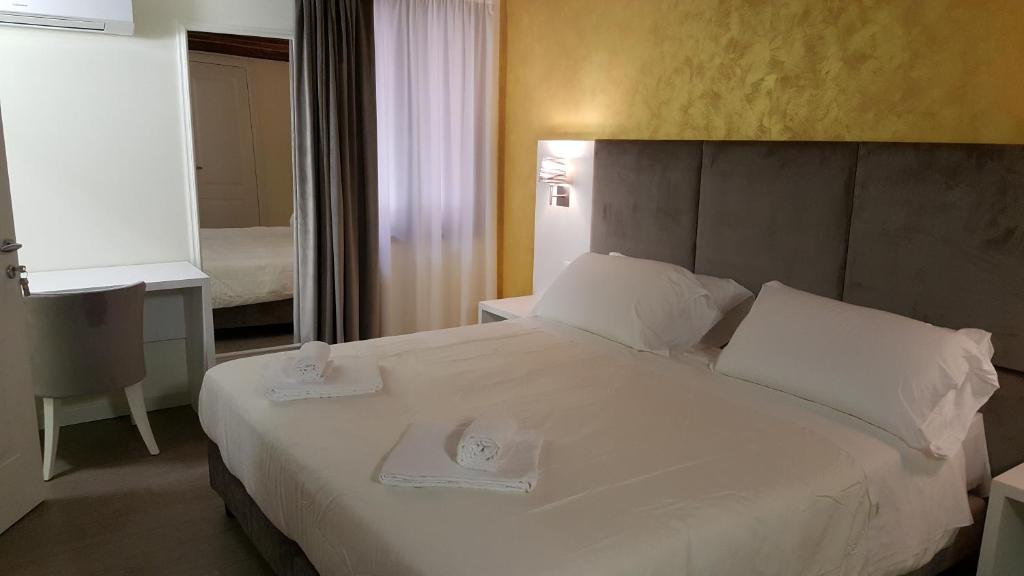 um quarto com uma grande cama branca com dois pratos em Maison d'Elite Guest House em Veneza