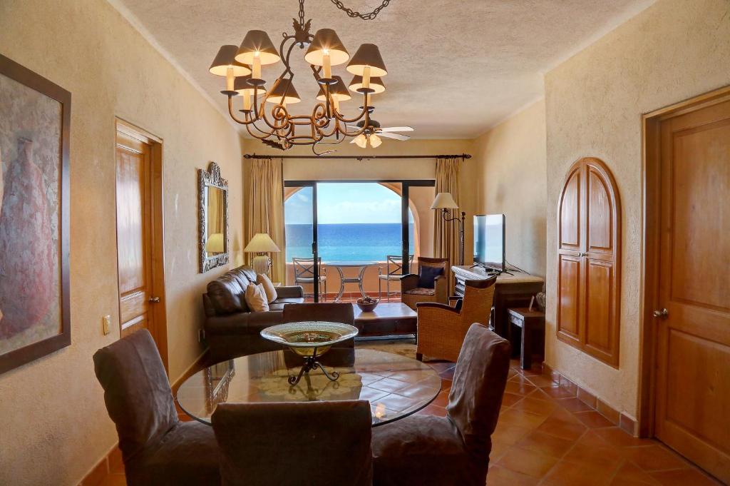 una sala de estar con mesa y sillas y el océano en Condominios La Luna - Ocean Front, en Cabo San Lucas