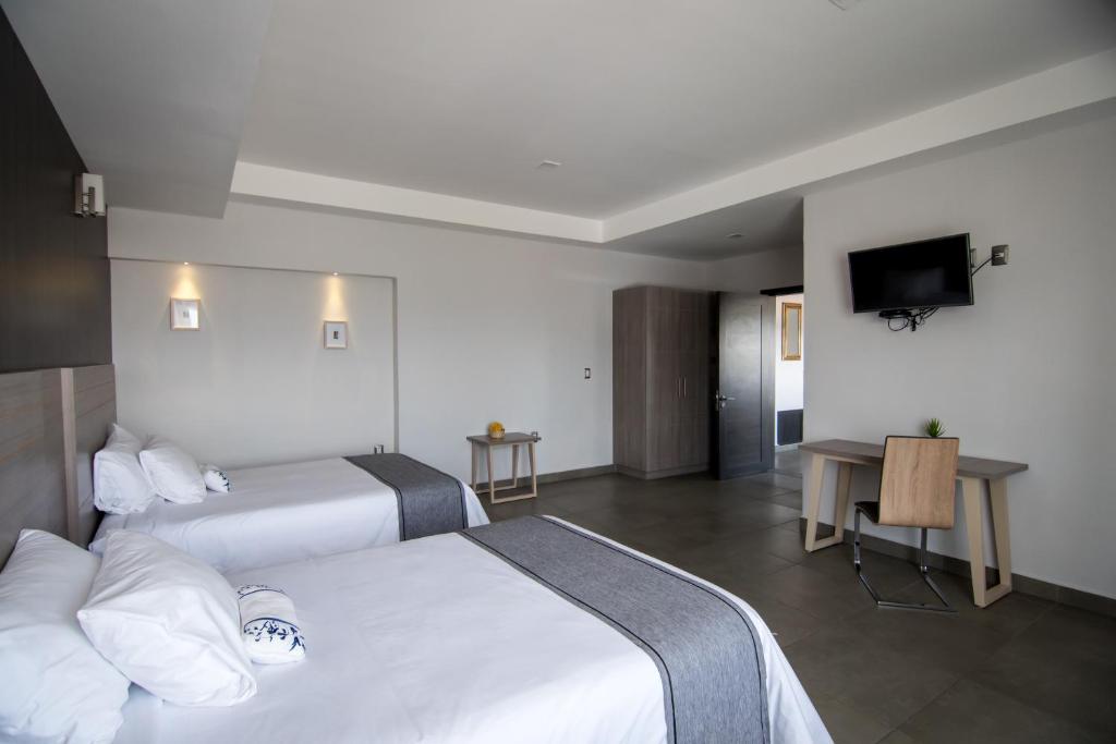 Postel nebo postele na pokoji v ubytování Maria Ines Hotel Suite