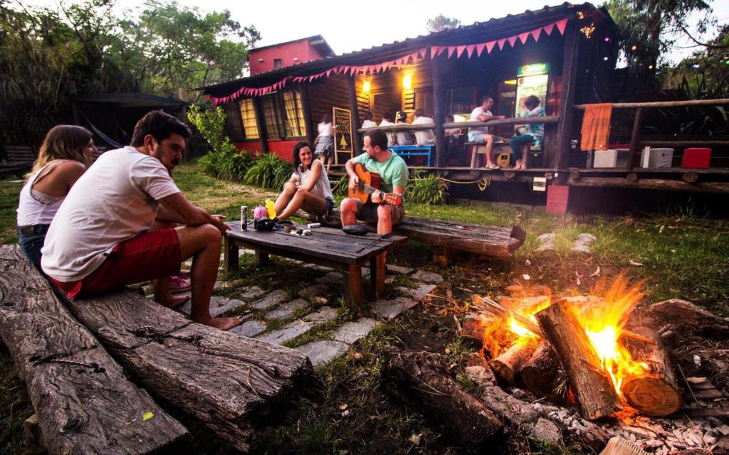 un grupo de personas sentadas alrededor de un campamento de fuego en Viajero La Pedrera Hostel, en La Pedrera