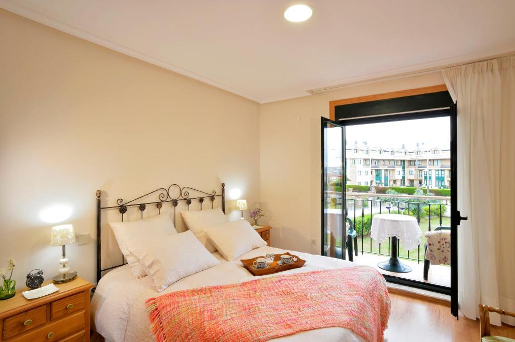 una camera con un grande letto e un balcone di A Mariña Adelina a Barreiros
