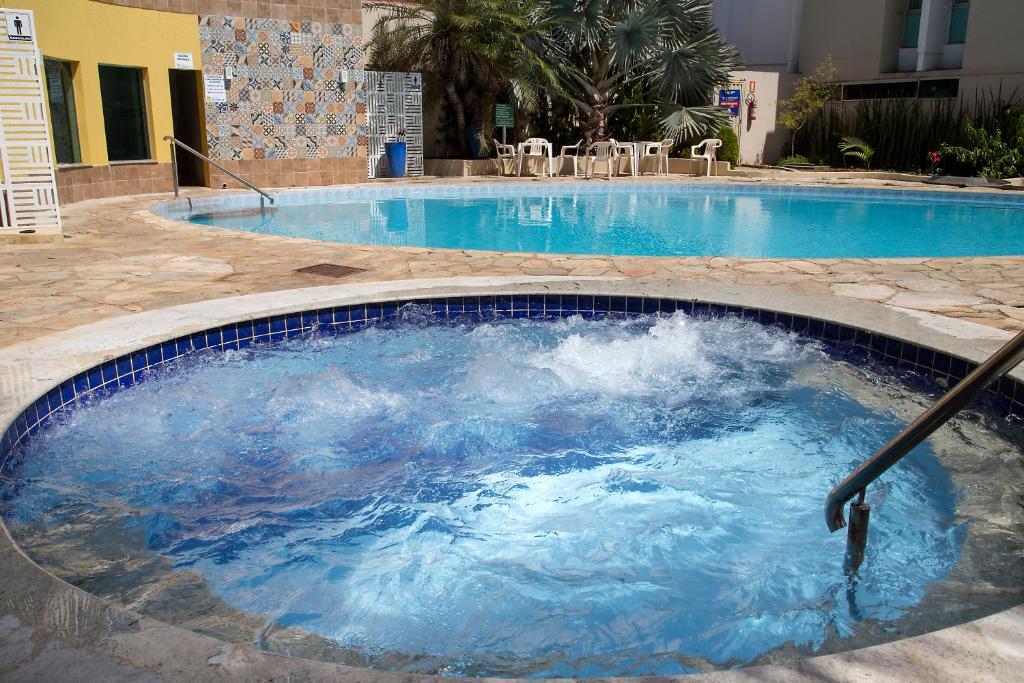 uma grande piscina com água azul em Hotel Morada das Águas em Caldas Novas