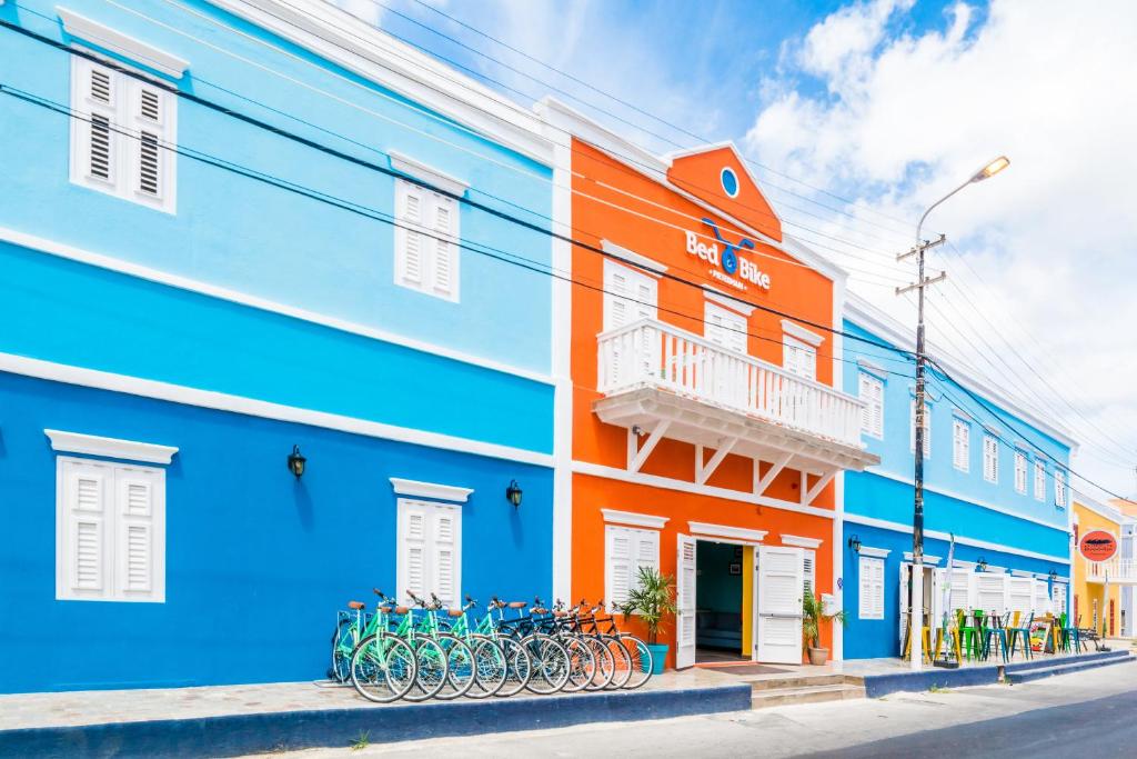 um edifício colorido com bicicletas estacionadas em frente em Bed & Bike Curacao em Willemstad