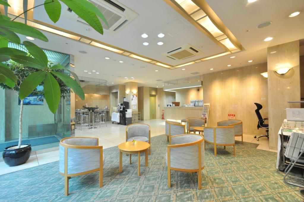 um lobby com mesas e cadeiras e uma planta em Kobe City Gardens Hotel (Formally Hotel Kobe Shishuen) em Kobe