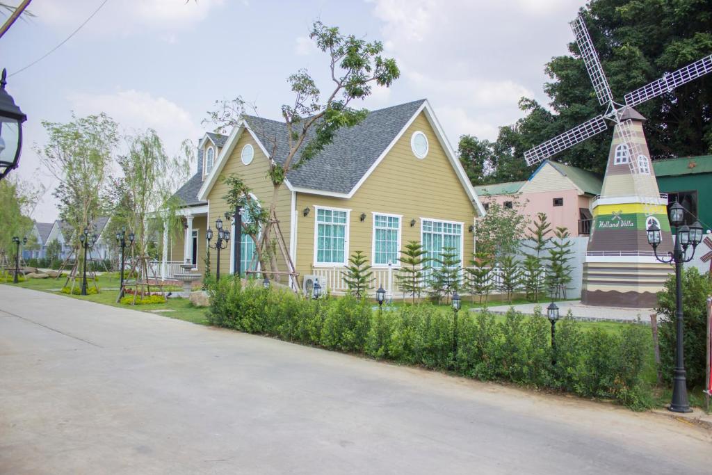OB-Oon Resort في أرانيابراثيت: منزل أمامه طاحونة هواء