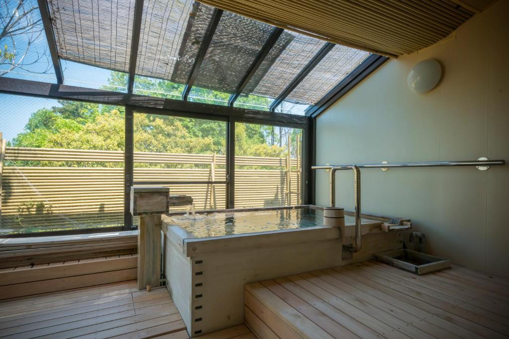 Cette grande chambre dispose d'une grande fenêtre et d'une table en verre. dans l'établissement Ryotei Manyou, à Nomi