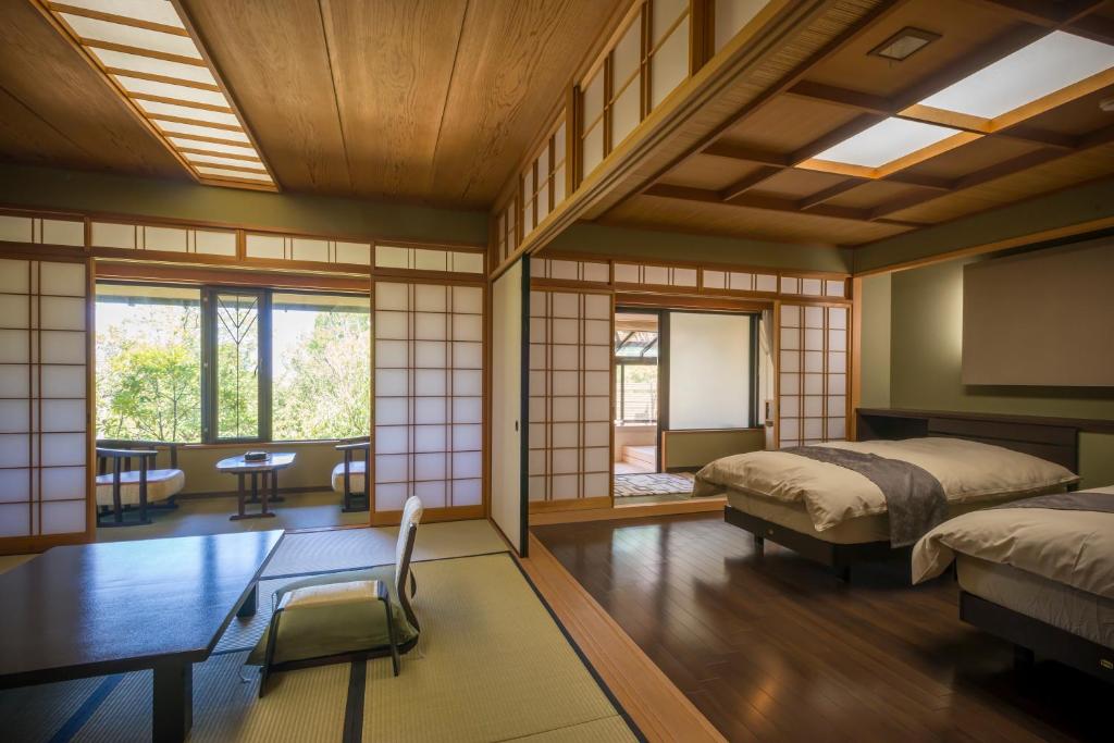- une chambre japonaise avec 2 lits et une table dans l'établissement Ryotei Manyou, à Nomi