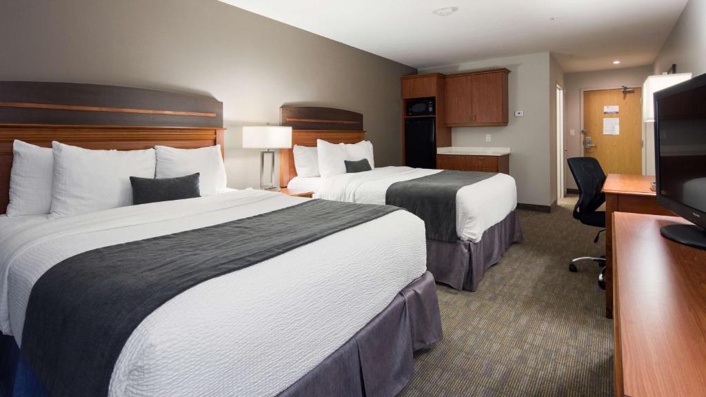 a hotel room with two beds and a flat screen tv at Best Western Plus Moncton in Moncton