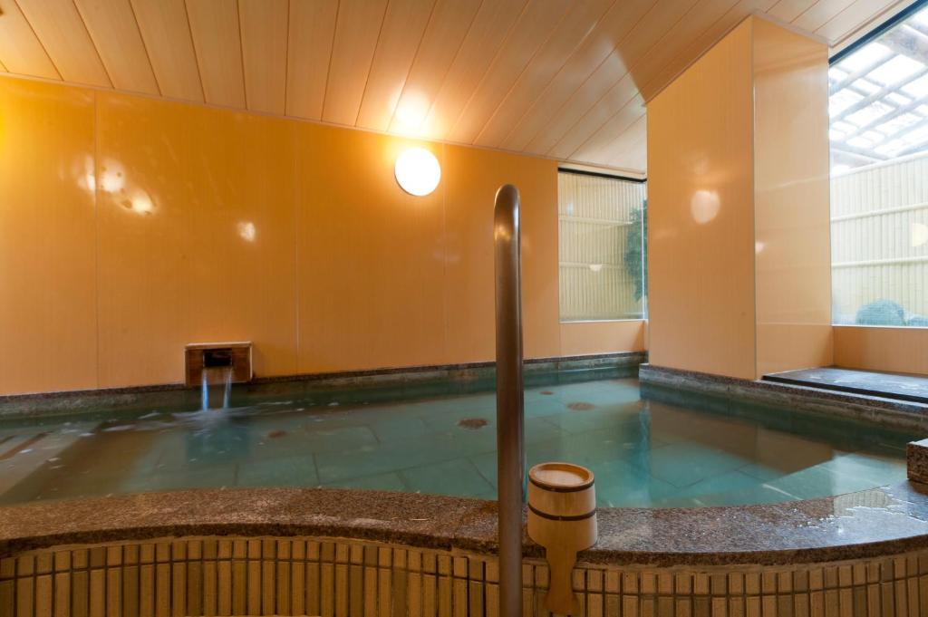 une grande piscine d'eau dans un bâtiment dans l'établissement Ryotei Manyou, à Nomi
