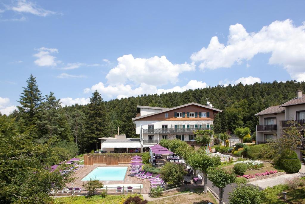 een luchtzicht op een resort met een zwembad bij Logis Hôtel Clair Matin in Le Chambon-sur-Lignon