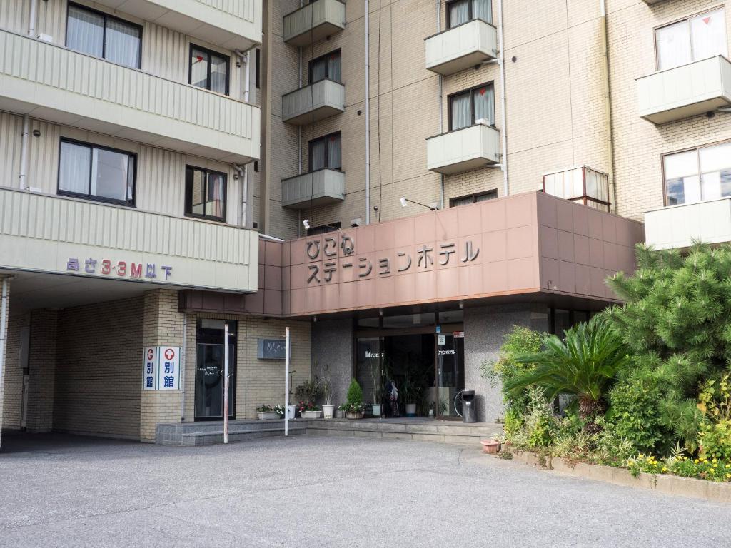 a building with a parking lot in front of it at Hikone Station Hotel in Hikone