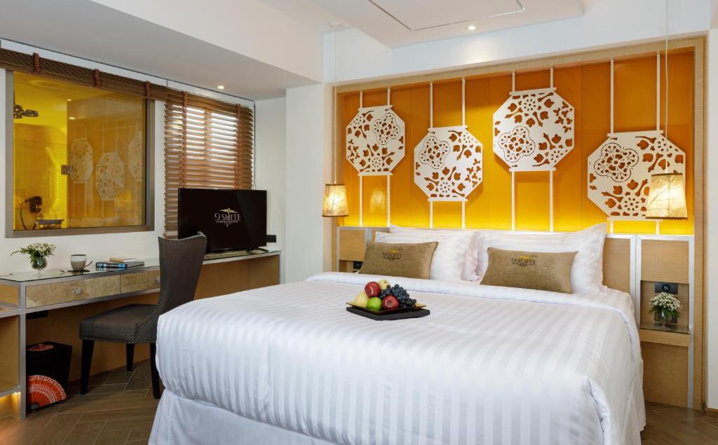 a bedroom with a large bed with a tray of fruit on it at 9 SUITE Luxury Boutique Hotel in Chiang Mai