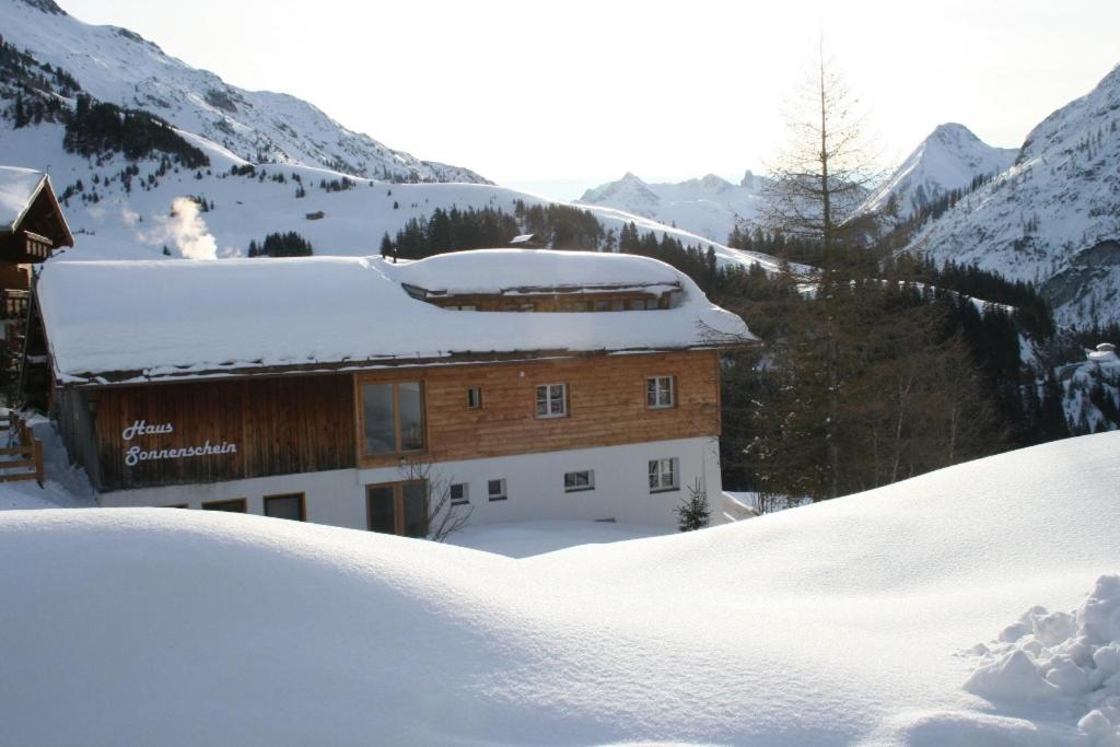 ein Gebäude mit Schnee auf dem Dach auf einem Berg in der Unterkunft Haus Sonnenschein in Warth am Arlberg