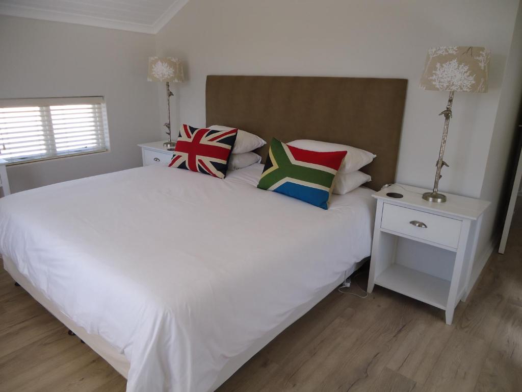 a bedroom with a white bed with pillows on it at 103 The Dunes in Keurboomstrand