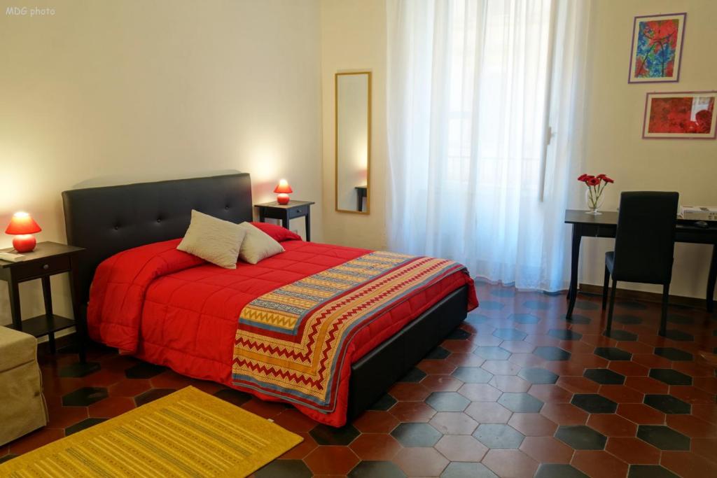 ローマにあるAppartamento a uso turisticoのベッドルーム1室(赤い毛布とテーブル2台付)
