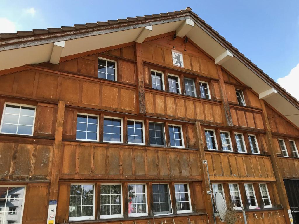 um edifício de madeira com janelas do lado em Hof Dietrich em Herisau