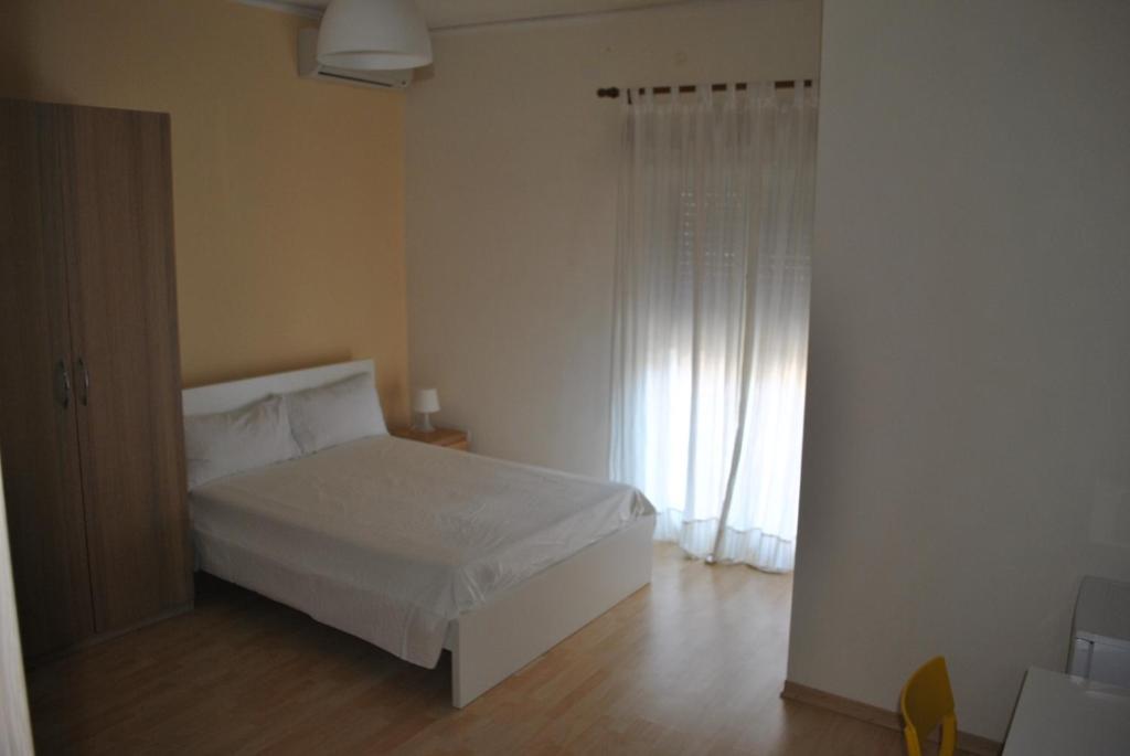 a bedroom with a white bed and a window at Residence Demetra in Gela