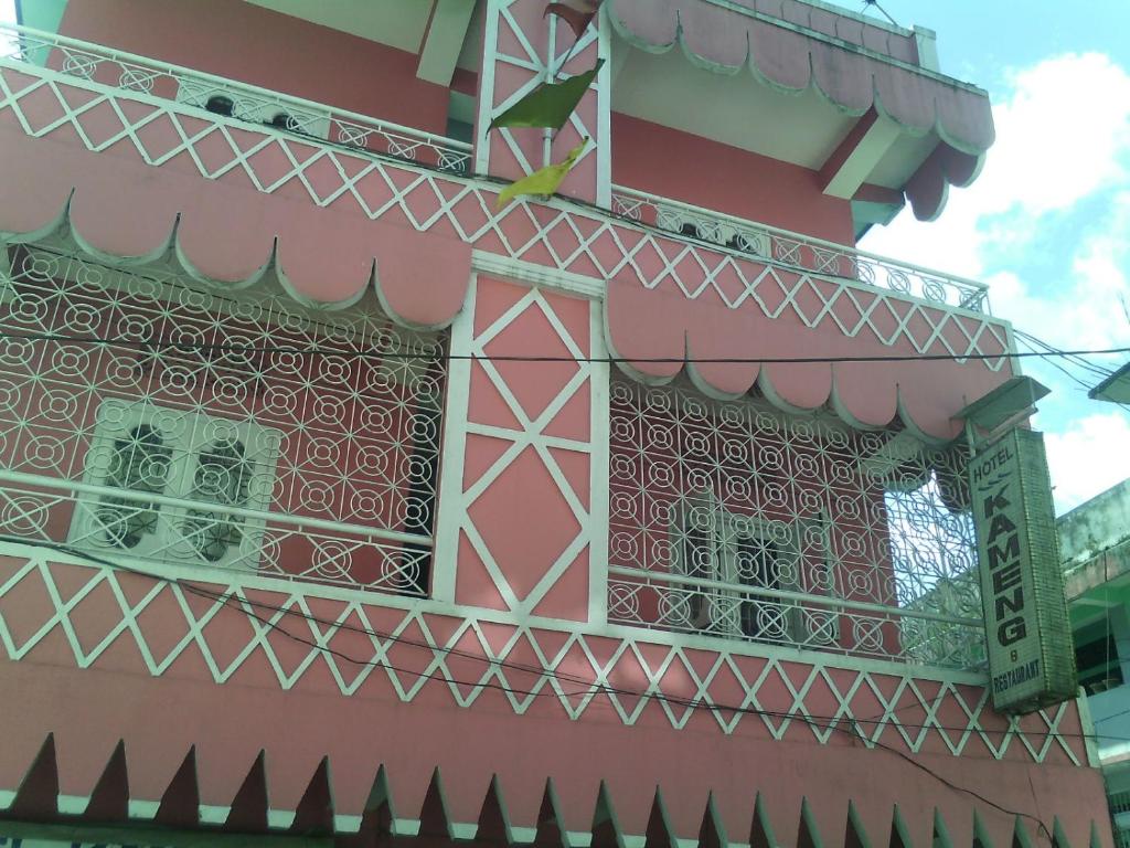 un edificio de color rosa con un balcón en el lateral. en Hotel Kameng, en Itānagar