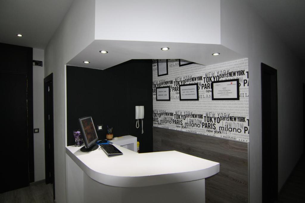 a bathroom with a white sink and a wall with writing at Hostal MH Fuencarral in Madrid