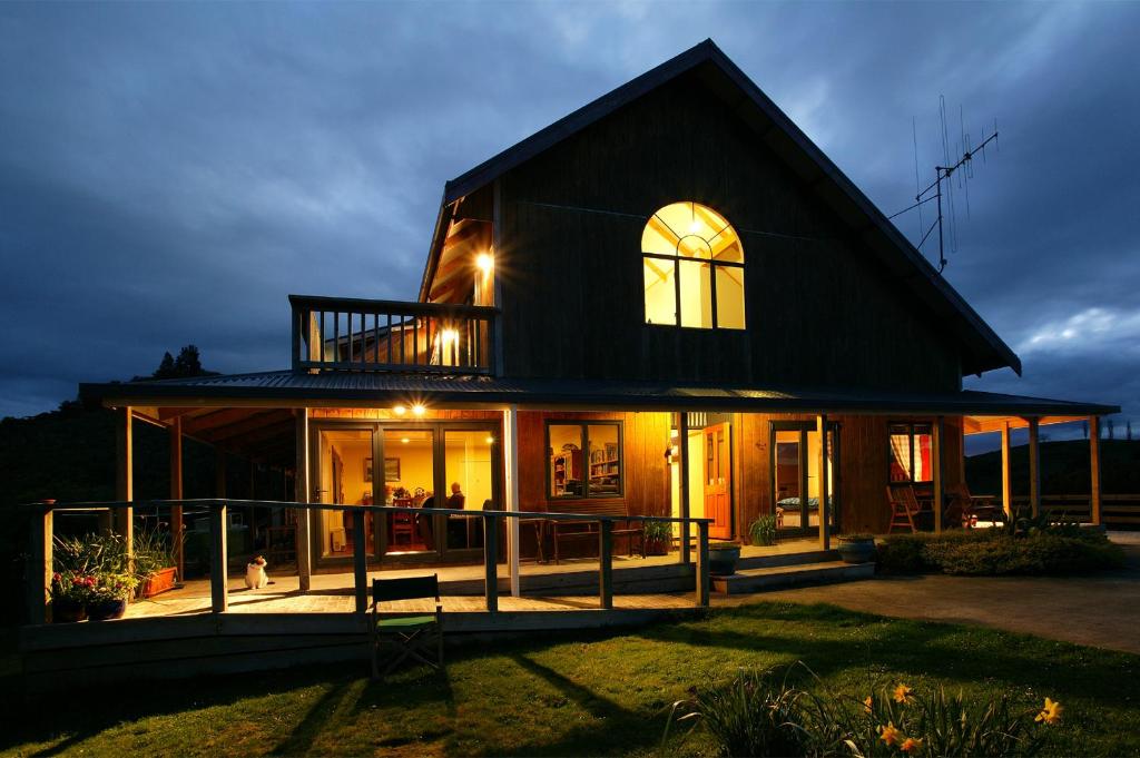 uma casa com um telhado de gambrel à noite em Abseil Inn em Cavernas de Waitomo