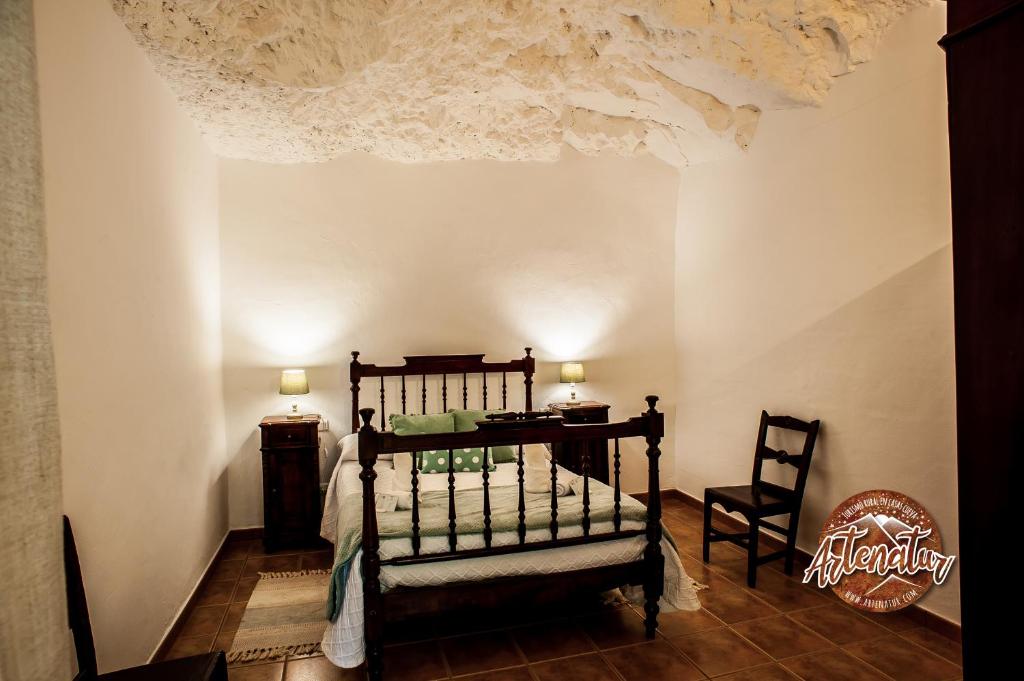 a bedroom with a bed and a table and a chair at Casa Cueva El Molino in Artenara