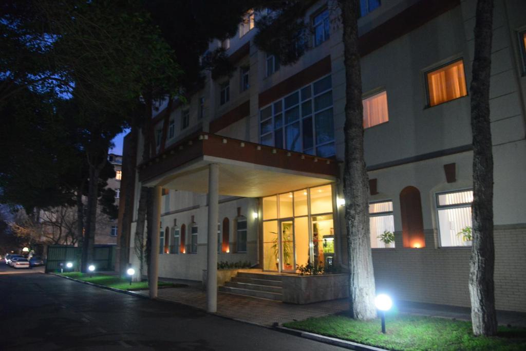un edificio de noche con luces delante en City Mansion ApartHotel, en Baku