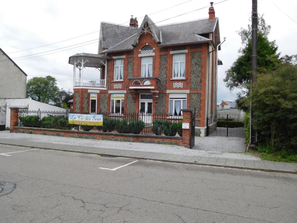 dom z czerwonej cegły na rogu ulicy w obiekcie La Cle des Sens w mieście Le Faubourg