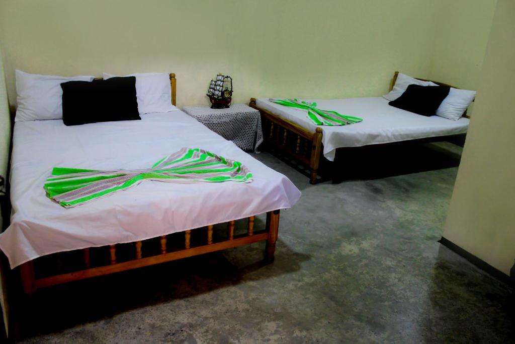 two beds in a room with green ribbons on them at J hostel kandy in Kandy