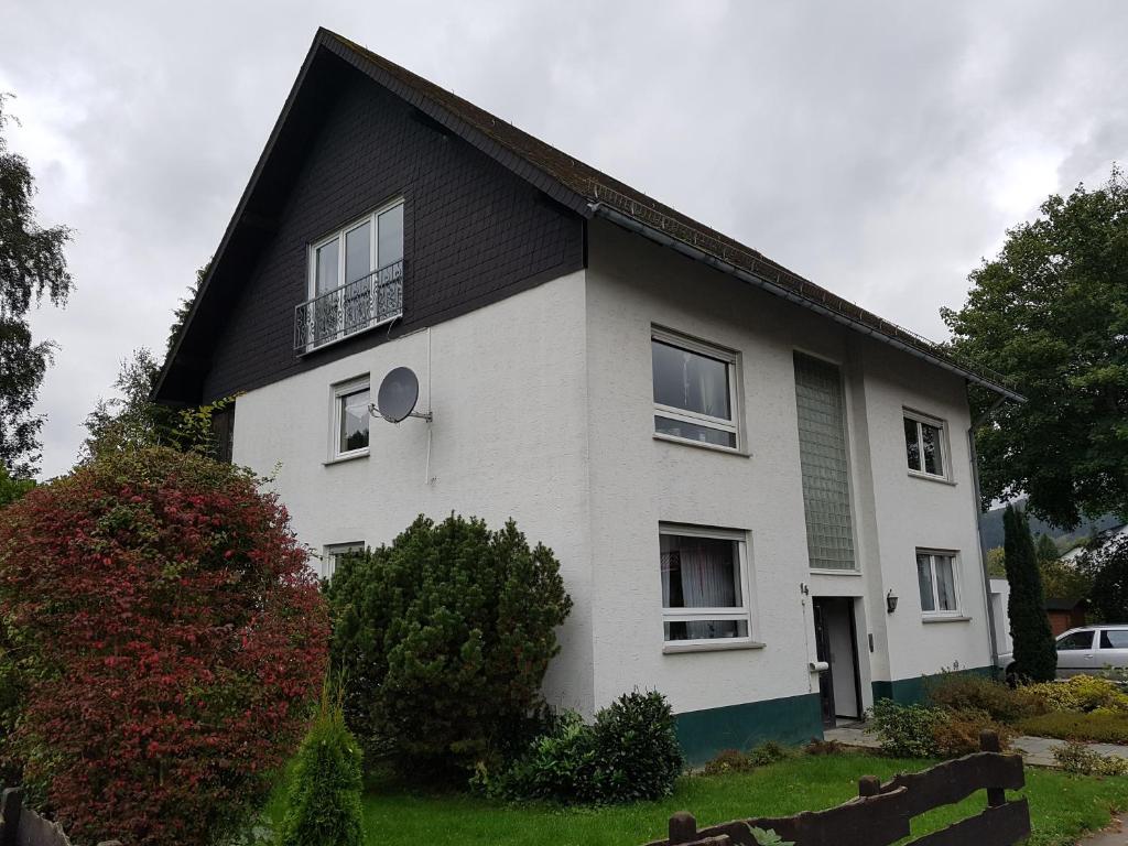 uma casa branca com um telhado preto em Ferienwohnung Grothoff em Olsberg