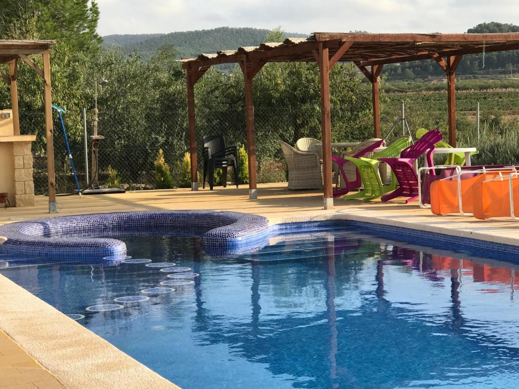uma piscina com um gazebo e cadeiras em Cortijo de los Castellanos em Las Ventanas