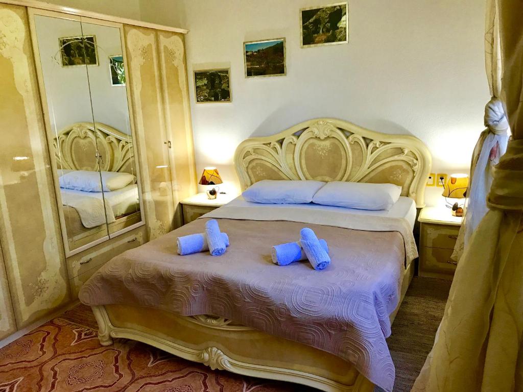 Un dormitorio con una cama grande con almohadas azules. en RAMIS Hotel & Outdoor Sports Center, en Përmet