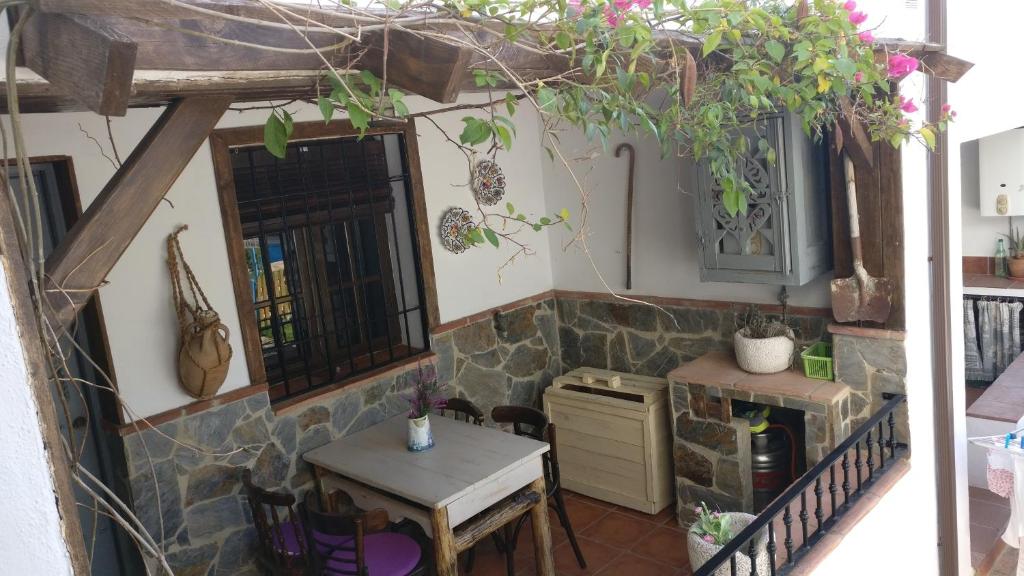 cocina y comedor con mesa y pared de piedra en Vivienda Rural la Terracita, en Montejaque