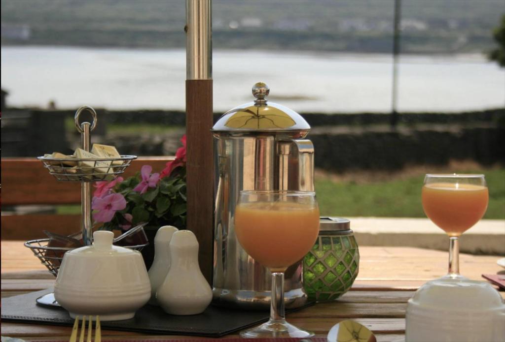 una mesa con dos vasos de zumo de naranja y una licuadora en Seacrest B&B en Kilronan