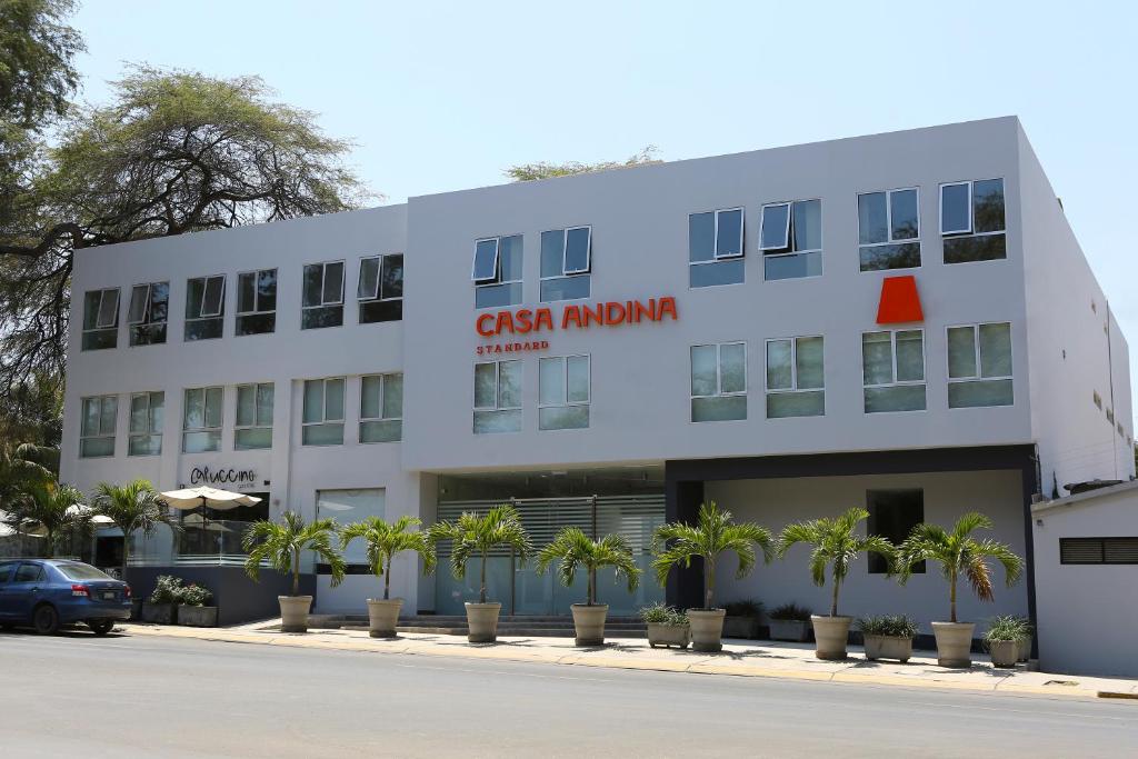 un edificio blanco con un letrero rojo. en Casa Andina Standard Piura, en Piura