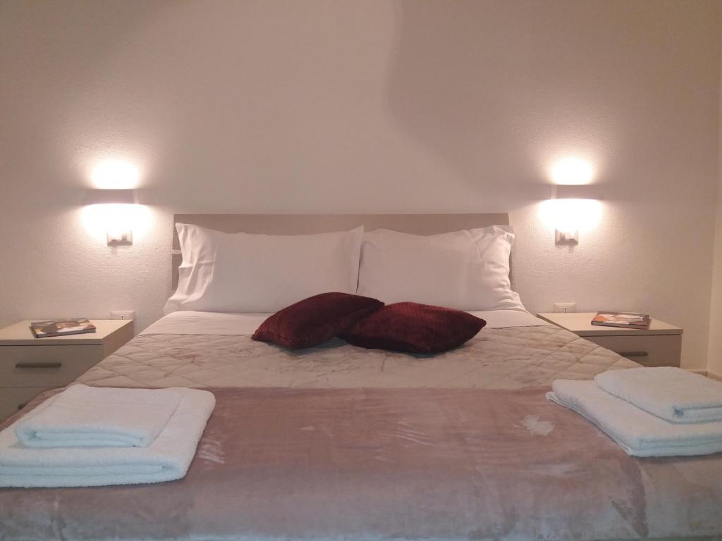 1 cama con 2 almohadas y 2 toallas. en Depandance Machiavelli, en Cagliari