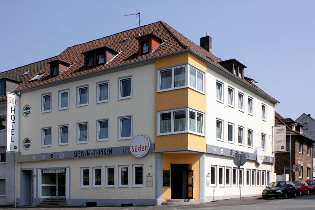ein großes weißes Gebäude mit braunem Dach in der Unterkunft Südhotel in Paderborn