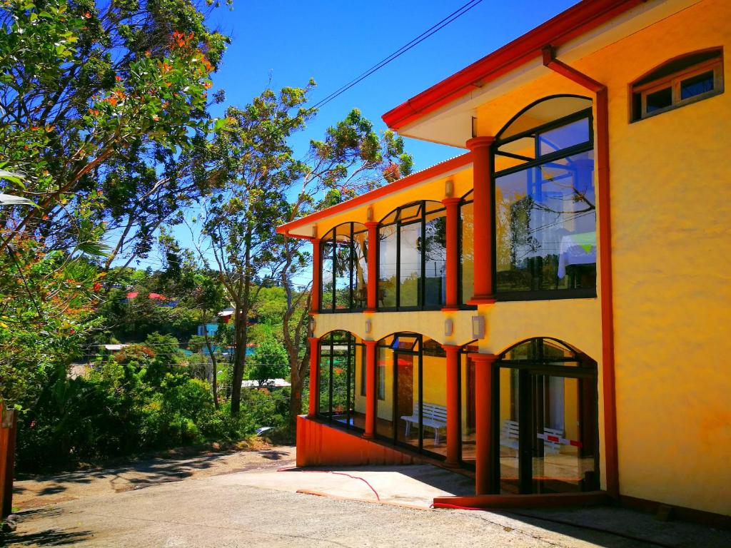 un bâtiment orange et blanc avec des fenêtres sur une rue dans l'établissement Hotel Santa Fe B&B, à Monteverde Costa Rica