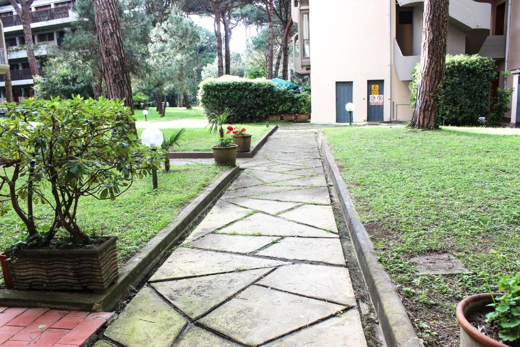 a stone walkway in a garden with trees and plants at Lagomare Puccini in Torre del Lago Puccini