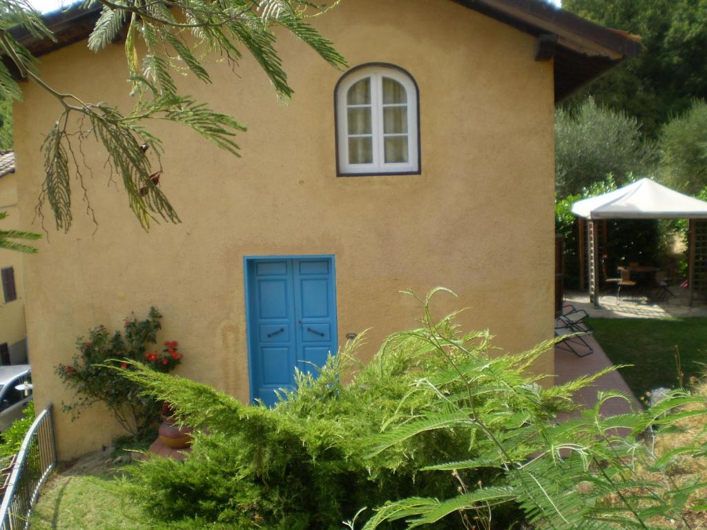 uma casa com uma porta azul e uma janela em casa al colle em Lucca
