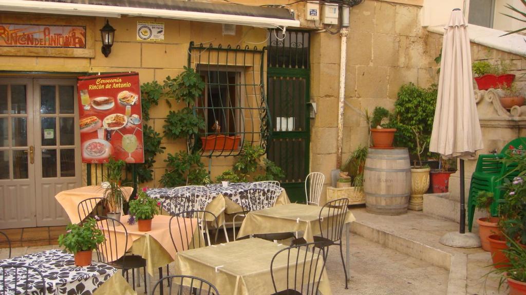 an outdoor patio with tables and chairs and an umbrella at Piso en el corazón de Alicante in Alicante