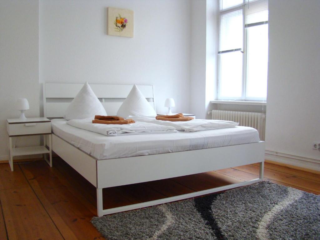 a white bed in a room with a window at Rooms & Apartments near Zoologischer Garten in Berlin